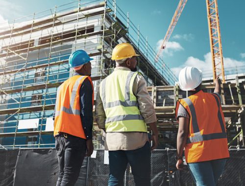 Shot of a group of builders assessing progress at a construction site Shot of a group of builders assessing progress at a construction site